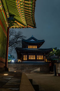 Low angle view of illuminated building against sky at night