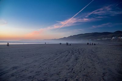 Scenic view of beach against sky during sunset