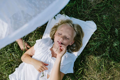 High angle view of woman lying on grassy field