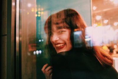 Portrait of smiling young woman using mobile phone