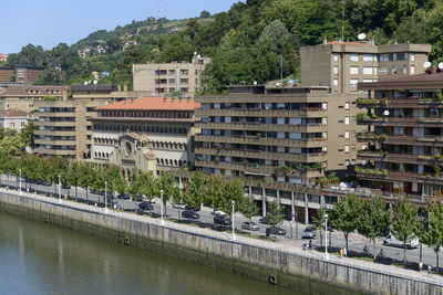 Buildings by river in city