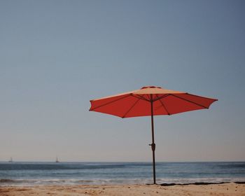 Beach umbrella at beach against clear sky