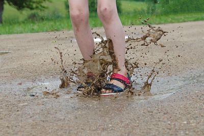 Low section of person standing on mud