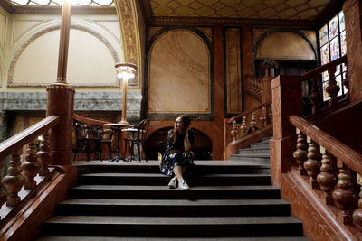 Rear view of woman on staircase in building