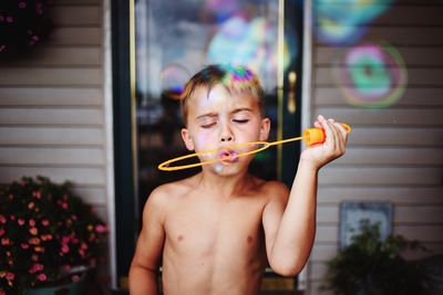 Portrait of shirtless boy holding food