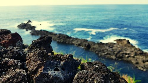 Rocks on sea shore against sky