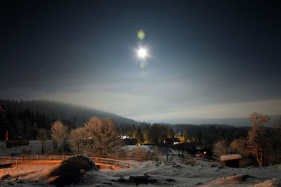 Moon over snowcapped landscape at night