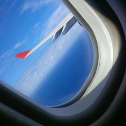 Close-up of airplane wing against blue sky