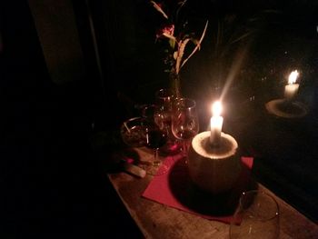 View of lit candle in dark room