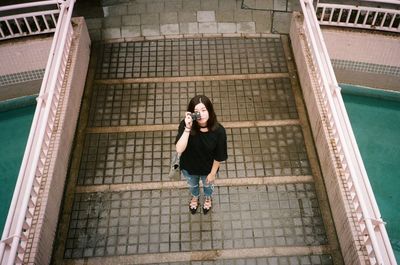 Full length of young woman on brick wall