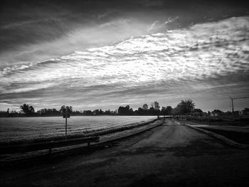 Road amidst field against sky