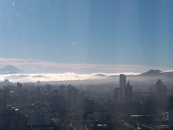 Aerial view of buildings in city against sky