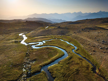 Scenic view of road by mountains against sky