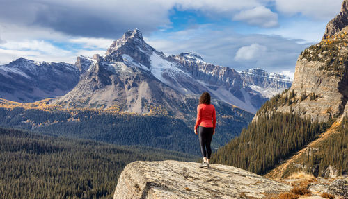 Rear view of woman looking at snowcapped mountain against sky