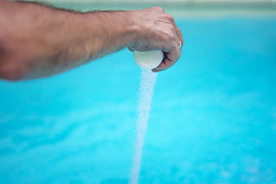 Midsection of person holding swimming pool