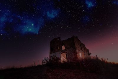 Low angle view of abandoned house against sky at night