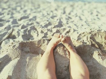 Low section of woman standing on beach