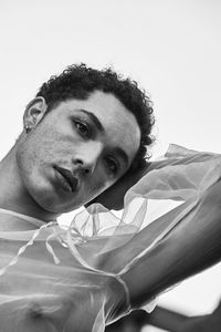 Young male with  androgynous look shot outdoor in black and white with rocks in background.