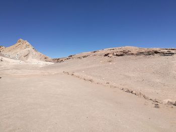 Scenic view of desert against clear blue sky