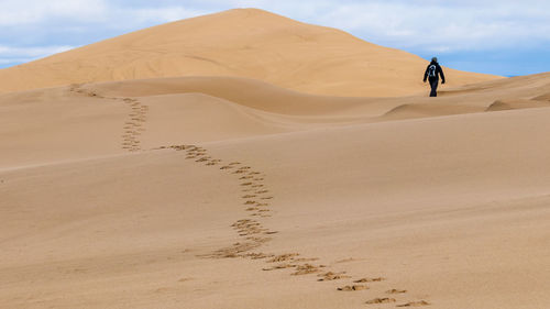 Low angle view of man walking in desert
