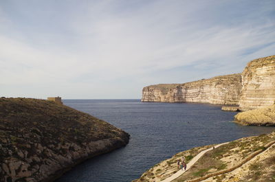 Scenic view of cliff in sea against sky