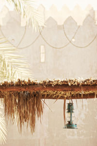 Oil lamp hanging from thatched roof against fortified wall