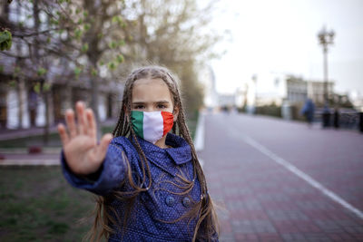 Portrait of girl gesturing while wearing mask