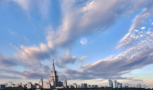 Buildings in city against cloudy sky