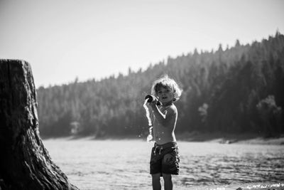 Boy playing in water against sky