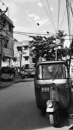 Cars on road against sky in city