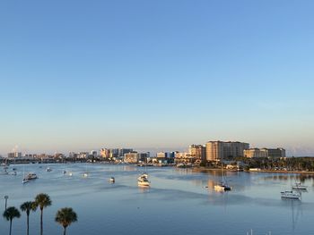 View of buildings and sea against clear blue sky