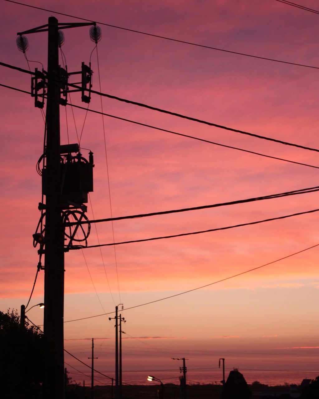 LOW ANGLE VIEW OF SILHOUETTE ELECTRICITY PYLONS AGAINST ROMANTIC SKY