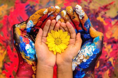 Close-up of woman hand holding multi colored flower