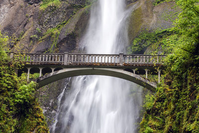 Scenic view of waterfall against bridge