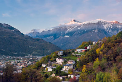 Aerial view of townscape by mountain against sky