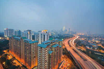 High angle view of illuminated city buildings against sky