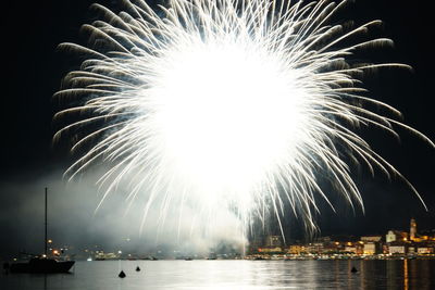 Firework display over river at night