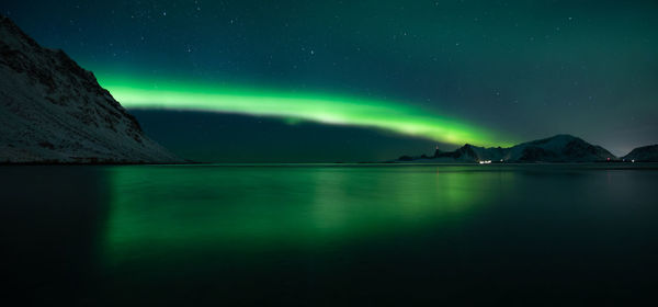 Scenic view of lake and mountains against sky at night