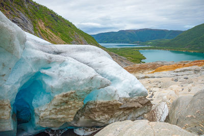 Scenic view of lake by mountain against sky