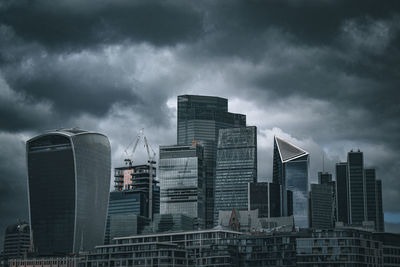 Buildings in city against cloudy sky