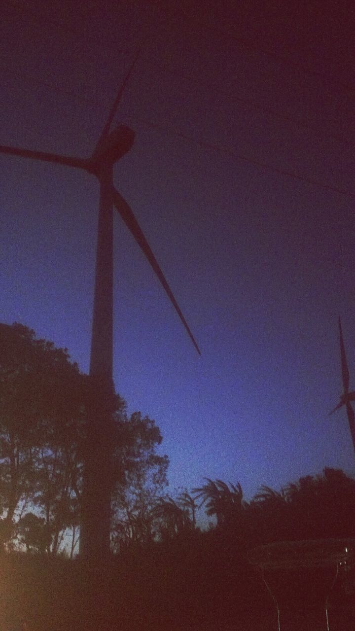 low angle view, tree, fuel and power generation, silhouette, sky, clear sky, built structure, nature, alternative energy, environmental conservation, wind power, dusk, renewable energy, wind turbine, tranquility, field, technology, windmill, architecture, outdoors