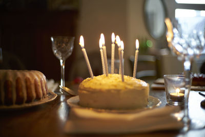 Close-up of burning candle on cake