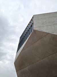 Low angle view of modern building against cloudy sky