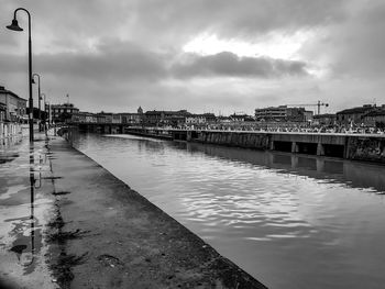 Bridge over river in city against sky