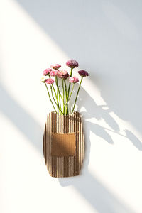 Small bouquet of flowers in cardboard vase.