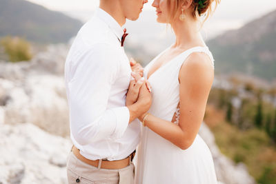 Midsection of couple standing outdoors