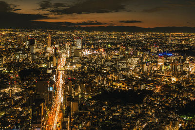 High angle view of illuminated cityscape against sky at night