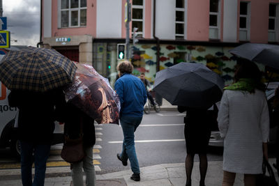 Rear view of people walking in rain