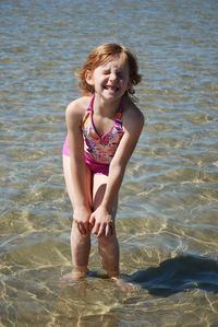 Portrait of happy girl standing in sea