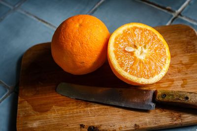 Close-up of oranges on cutting board at table